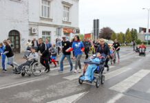 zdjęcie przedstawia bieg i uczestniczących w nim ludzi na wózkach