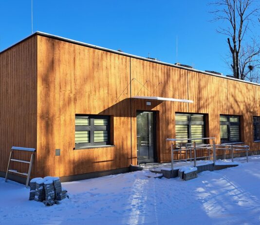 drewniany budynek z podjazdem dla niepełnosprawnych. wokół leży śnieg