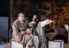 Scena ze spektaklu „Matka Courage i jej dzieci” w Teatrze Dramatycznym im. Aleksandra Węgierki w Białymstoku. Dwie aktorki w kostiumach siedzą na scenie, a jedna z nich wyciąga rękę w dramatycznym geście.